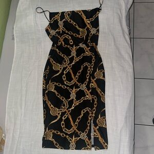 Woman Large Cocktail Dress with Black and Gold Chains stamped around the dress.